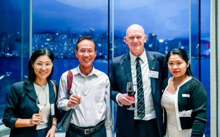 Four alumni posing for a photo at a Reception in Hong Kong.